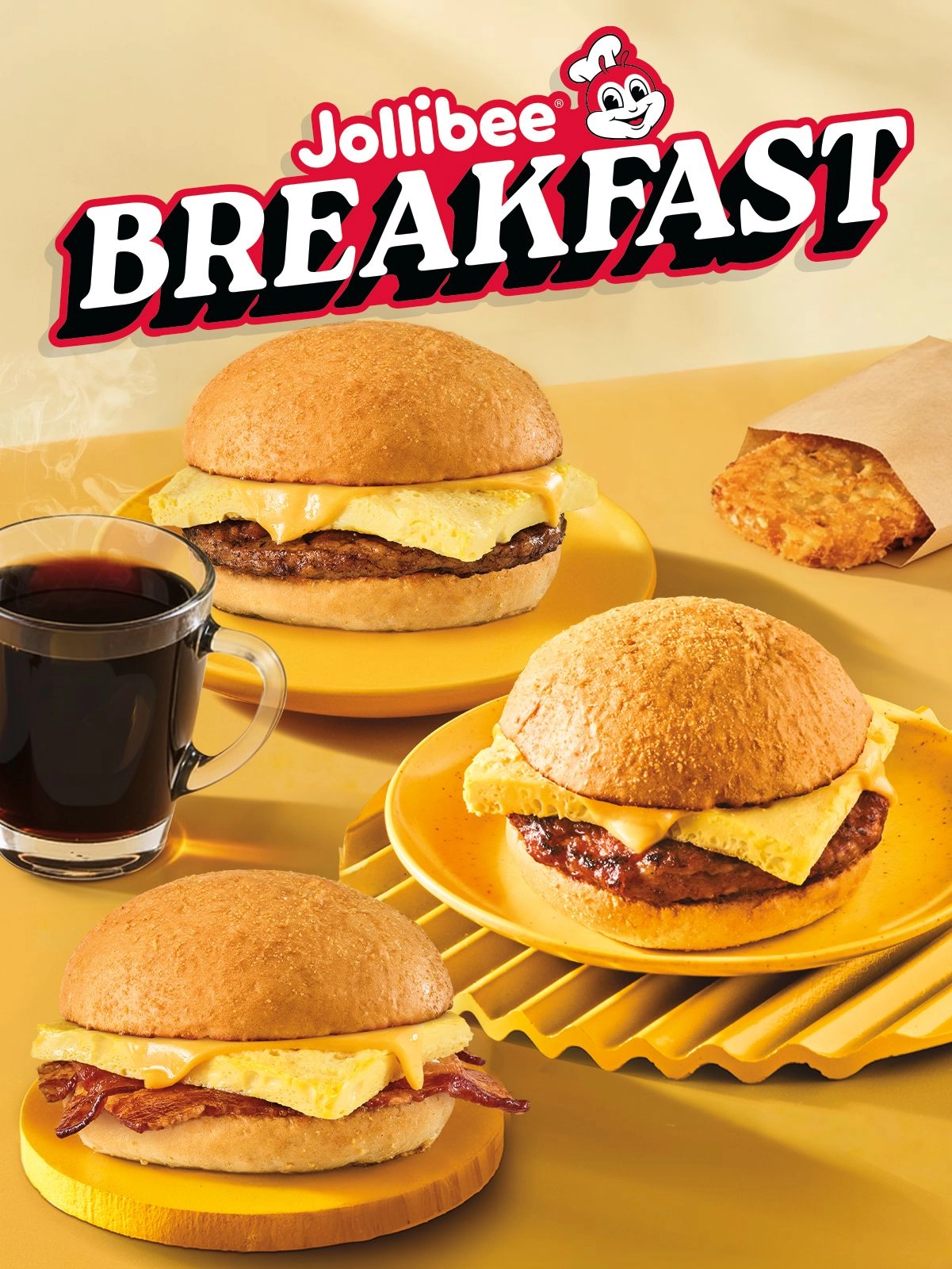 Three breakfast pandesal sandwiches with hash browns and coffee, and Jollibee Breakfast text on a yellow background.